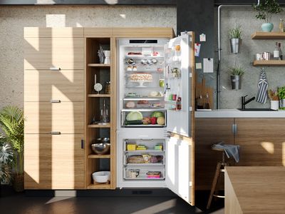 Didelis XXL šaldytuvas-šaldiklis pravertomis durimis šviesioje medžio apdailos virtuvėje