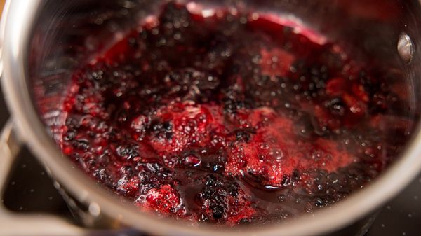 Blackberry maple syrup mixture simmering in pan