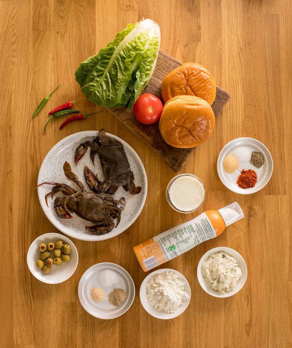 Numerous individual ingredients for crab burgers on counter top