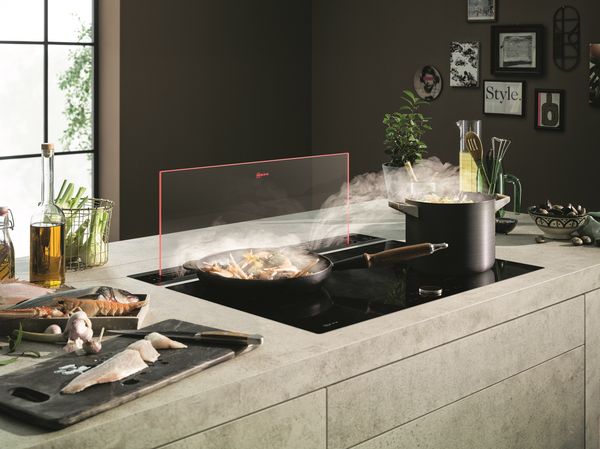 A retractable cooking island hood serves as a privacy screen 