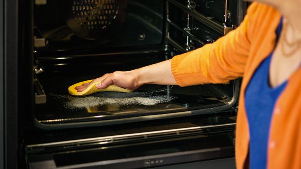 Woman wiping ash from NEFF Pyrolytic Self-cleaning Oven