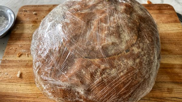 Besmeer de kap van het brood aan de binnenzijde met de rest van de pesto en leg het met de besmeerde kant bovenop de uien.