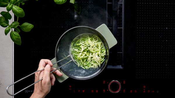 Placing courgetti into boiling water