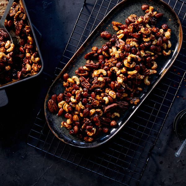 Overhead shot of final spicy nuts recipe in baking tray and then served on long dish