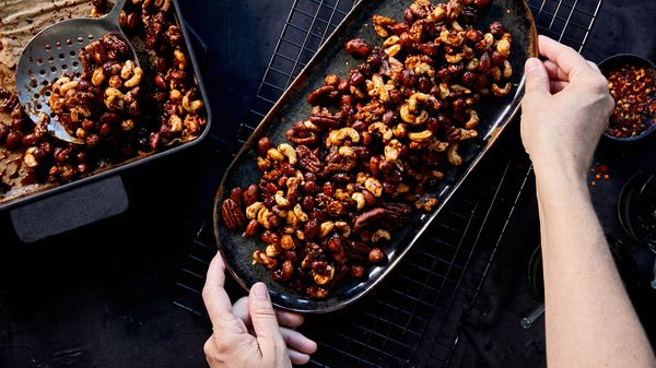 Person serving final cooked nuts in long dish