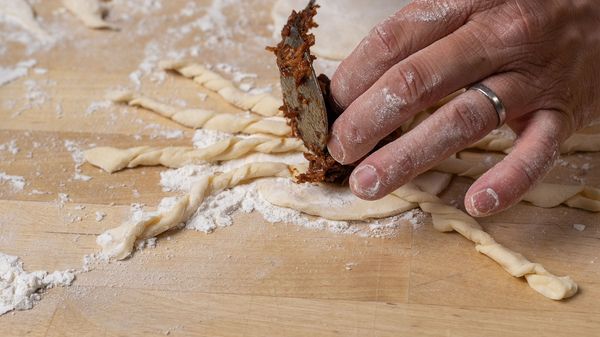 Person putting filling into puff pastry circles