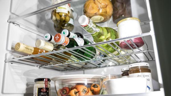 Bottle Flex Shelf inni kjøleskapet som viser trygg oppbevaring av flasker uten risiko for at de ruller rundt 