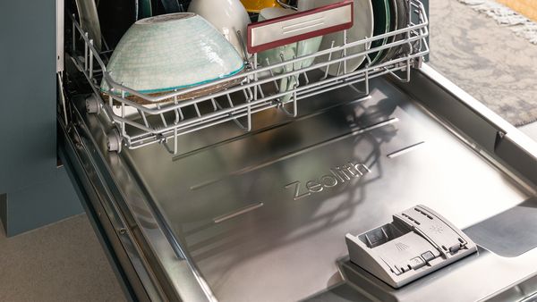Vue rapprochée d'un lave-vaisselle ouvert contenant de la vaisselle complètement sèche à l'intérieur.
