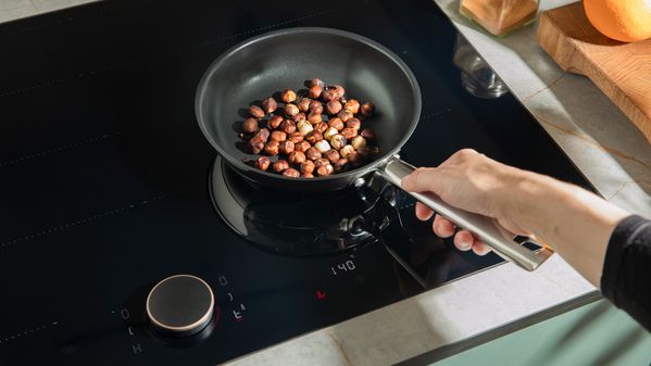 hazelnuts are being roasted in a pan