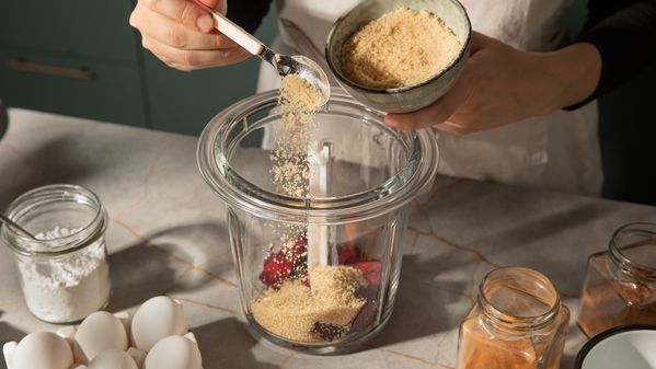 someone adds the hazelnuts to the beetroot in a blender