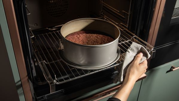 a person takes the baking tin containing the chocolate cake out of the NEFF oven