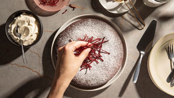 the cake is being decorated with icing sugar and beetroot rasps