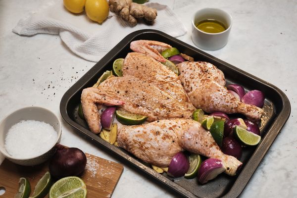 Cut onions in half, keeping the skins on and surround the chicken