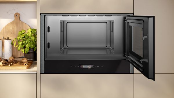 A built-in NEFF microwave integrated in a brown kitchen