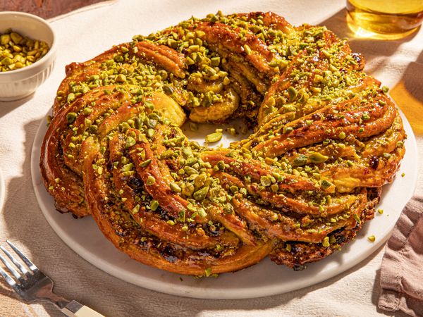 Golden brown baked braided Easter bread with pistachio and cranberry filling formed like a wreath