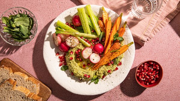 Mint hummus, served with freshly chopped vegetables on a serving plate 