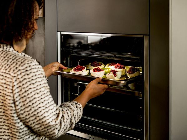 Women using NEFF Slide&Hide oven to cook