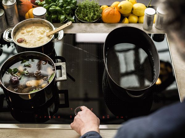 Person cooking with a NEFF induction hob using TwistPad