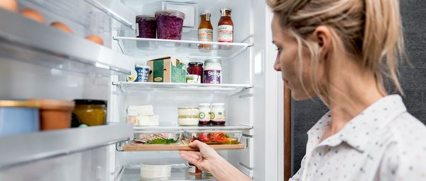 Woman removing NEFF Gourmet Tray from fridge