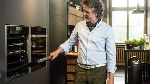 Man using NEFF appliances in kitchen scene