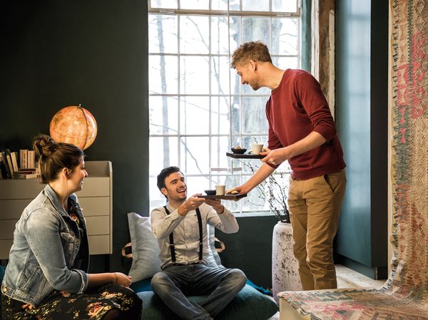 Man serving coffee in living room area