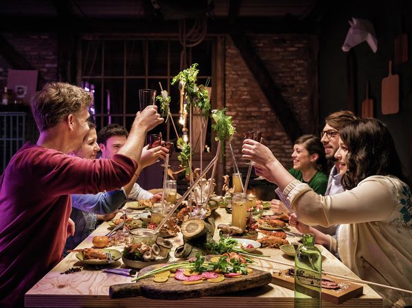 People raising a glass at dinner party