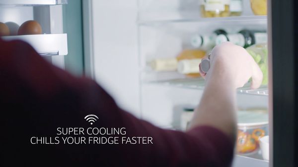 Man removing bottle from NEFF fridge