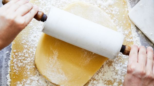 Person using rolling pin on dough