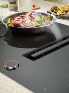 A NEFF Vented Hob with a Frying Pan in use with a stream extration
