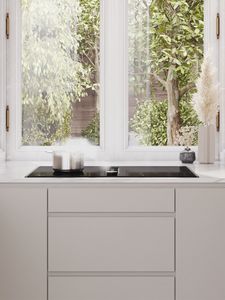 View of a bright modern kitchen with a hob with integrated ventilation under the window