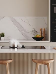 View of a bright modern kitchen with a hob with integrated ventilation installed in a kitchen island