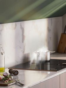 View of a modern kitchen with a hob with integrated ventilation installed under shelves in a sloping roof