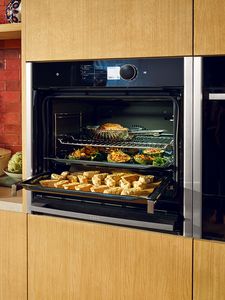 Neff slide and hide oven full of baking trays with food