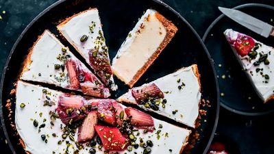 Cheesecake with rhubarb sauce, sliced into pieces garnished with pistachios