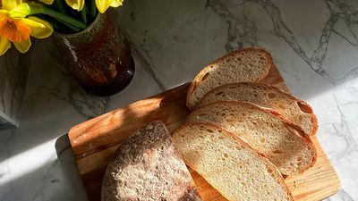 Golden baked and sliced bread, placed on a wooden plate