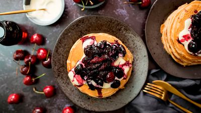 Vegan almond butter pancakes topped with vanilla yogurt and roasted cherries