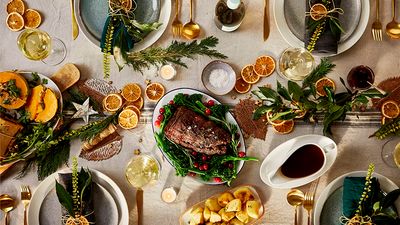 A table perfectly decorated for christmas and in the middle the brisket in cranberry and red wine sauce
