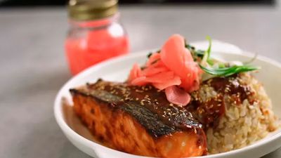 Salmon served with brown rice, topped with pickled ginger and sesame seeds