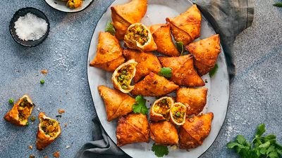 A bunch of crispy fried samosas, filled with paneer, peas and spices.