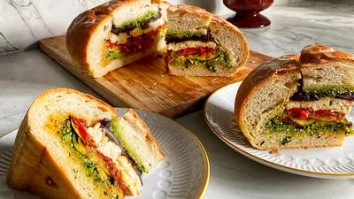 A filled bread with courgettes, onions, roasted tomatoes, onions and pesto, cut into slices