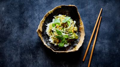 Piatto colorato in ciotola scura con bacchette di legno. 