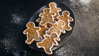 Multiple gingerbread people cookies decorated on a plate 