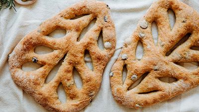 Freshly baked fougasse bread presented on a white cloth.