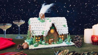 Festive Christmas gingerbread house decorated with icing and festive sprinkles.