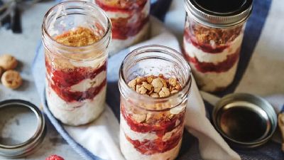 Vasetti di yogurt, granola e frutta con lamponi. 