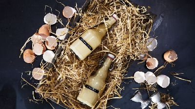 Due bottiglie di bevanda cremosa su paglia. 