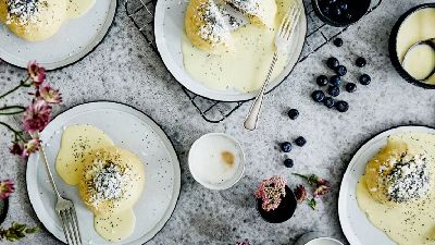 Dolce cremoso con mirtilli, fiori e salsa. 