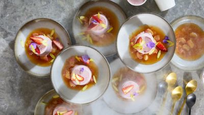 Sei coppette di gelato rosa con frutta e fiori. 