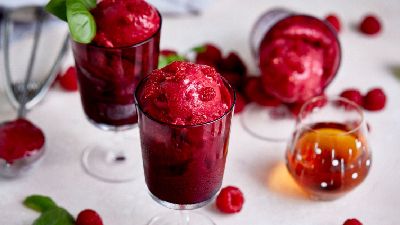 Tre bicchieri di sorbetto ai lamponi con basilico. 