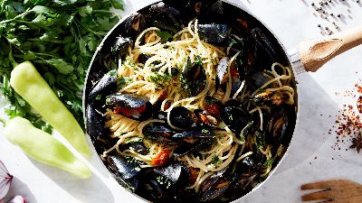 Spaghetti alle cozze con erbe e spezie su marmo. 